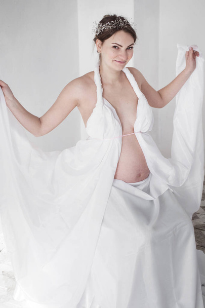 foto menina grávida com jóias em seu cabelo detém um cortinado branco
 - Foto, Imagem