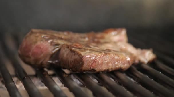Paistaa pihvi BBQ: llä. Tyypillinen argentiinalainen grilli tai asado. Puun polttaminen grillissä ja punaiset kuumat hiilet
. - Materiaali, video