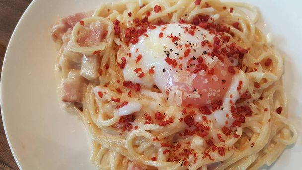 Domácí Špagety Carbonara s omáčkou na bílé plotně a smažené slaniny zdobené zeleninové papriky - Fotografie, Obrázek
