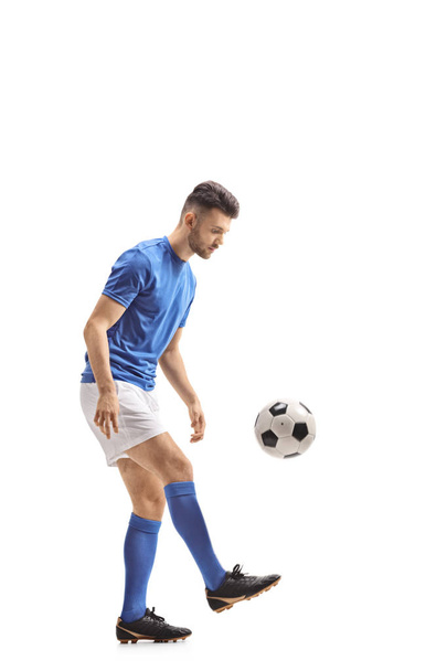 Full length profile shot of a soccer player with a football isolated on white background - Fotoğraf, Görsel