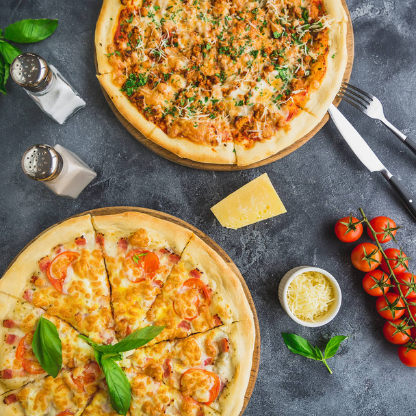 Delicious pizza with bacon, cheese, tomato on dark background. Flat lay. Top view. Delicious food background - Foto, imagen