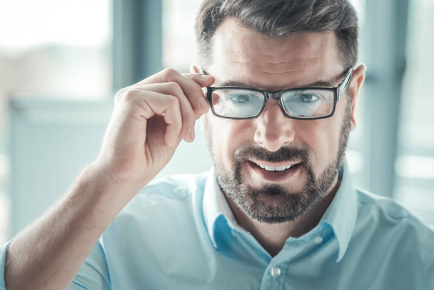 Delighted male person touching his glasses - Photo, image