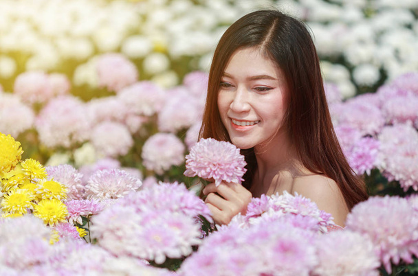 beautiful woman in chrysanthemum glower garden - Photo, Image