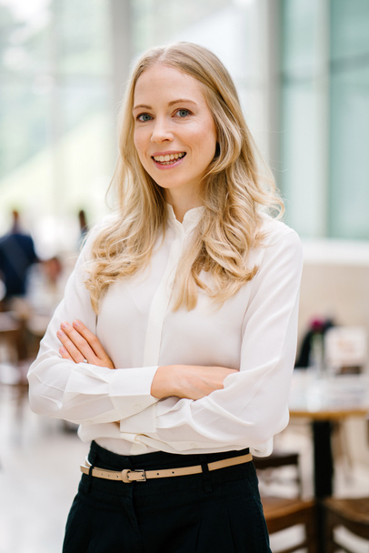 Professional portrait head shot of a Caucaasian woman expatriate working in Singapore, Asia. She is middle-aged in her 30's, attractive, blond and beautiful in a crisp white shirt in an office. - 写真・画像