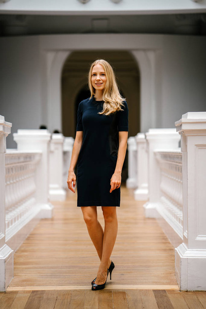 Portrait of a very beautiful white Caucasian woman in a black dress. She is blond with blue eyes, middle-aged, attractive, beautiful and smiling. She is a Russian expatriate living in Singapore. - Foto, Imagen