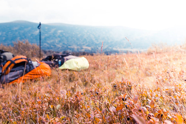 Two tourist backpack on autumn meadow in a mountain valley. Travel in the mountains, Hiking, rest on the way. - Fotó, kép