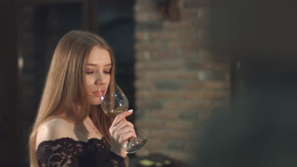 美しい少女は、ワインを飲んでいます。スローモーション。レンガの壁に女の子から移動します。美少女のワインセラーでワインの試飲. - 映像、動画