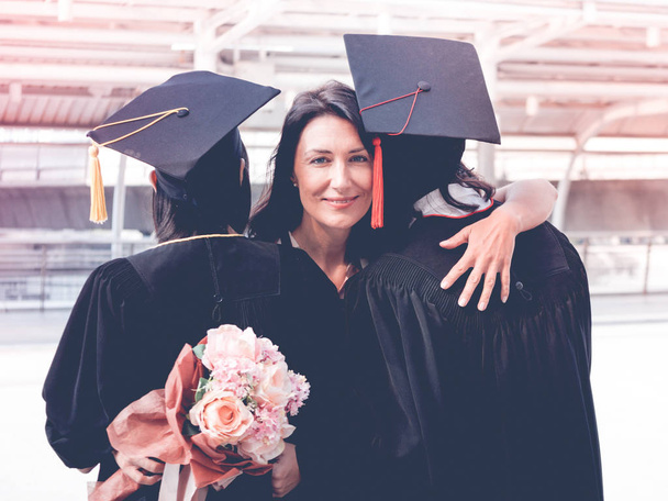 Hermosa mujer felicita por su familia en el día de la graduación, concepto exitoso
 - Foto, Imagen