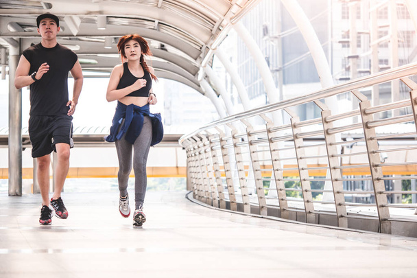 Młodych uczestników uruchomione na miasto most, sportowy para jogging rano z Bangkok miejski scena tło - Zdjęcie, obraz