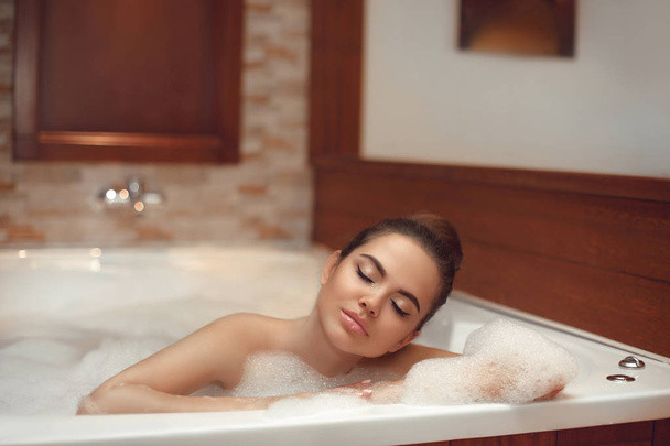 Skincare. Wellness. Beautiful Young woman relaxing in jacuzzi ba - Foto, afbeelding