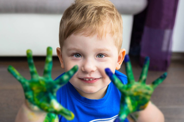 Маленький хлопчик з барвистою фарбою на руках
 - Фото, зображення