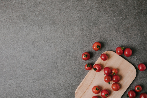 top view of fresh ripe tomatoes on wooden board on grey - Valokuva, kuva