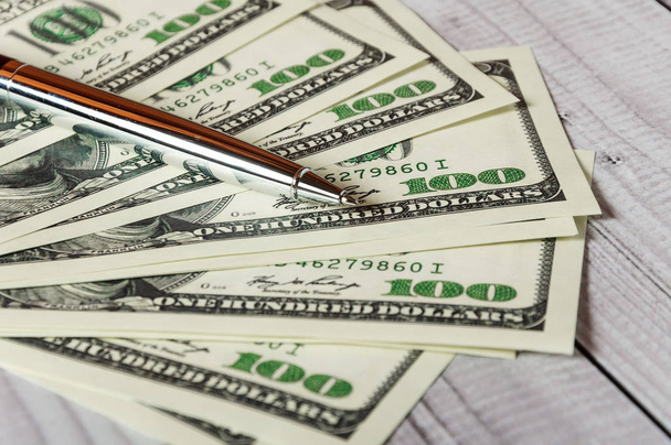 Το σημειωματάριο, στυλό και χρήματα σε ανοιχτόχρωμο φόντο ξύλινη - Φωτογραφία, εικόνα
