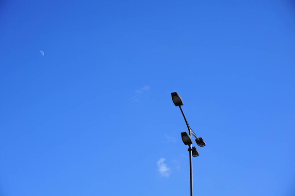 Luces de calle a la luz del día contra un hermoso cielo azul con nubes blancas
 - Foto, imagen