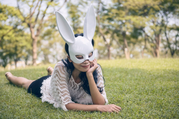 Kobieta z maska biały królik w ogrodzie - Zdjęcie, obraz