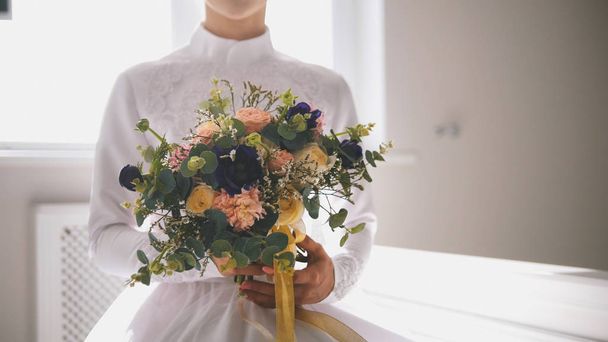 Mooie moslim bruid bedrijf boeket bloemen in handen - Foto, afbeelding