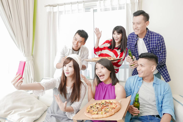 young people eating pizza and taking selfie happily on  party - Foto, afbeelding