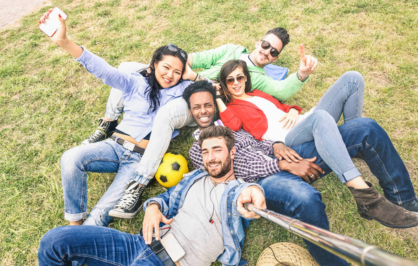 Multiracial best friends taking selfie at meadow picnic - Happy friendship fun concept with young people millennials having fun together outddors on spring summer time - Neutral afternoon filter - Photo, Image