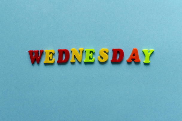word "wednesday" of colored plastic magnetic letters on blue pap - Fotografie, Obrázek