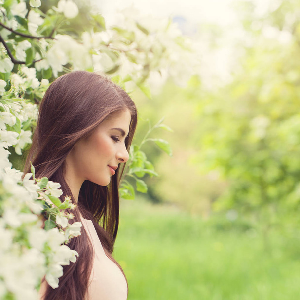 Joven mujer perfecta sobre fondo de flor de primavera
 - Foto, Imagen