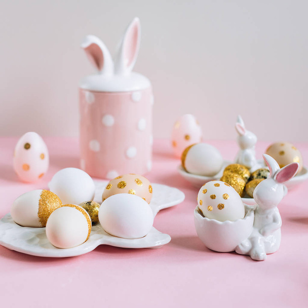 Golden glitter Easter eggs on plate in shape of rabbit on pink background - Φωτογραφία, εικόνα