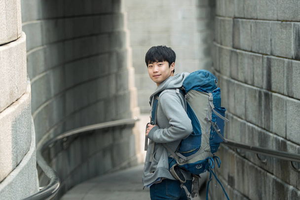 Молодой человек путешествует в походе в корейском традиционном доме
. - Фото, изображение