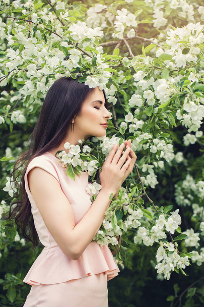 Τέλεια νεαρή γυναίκα μυρίζοντας λουλούδι λουλούδια ανθίζουν άνοιξη - Φωτογραφία, εικόνα
