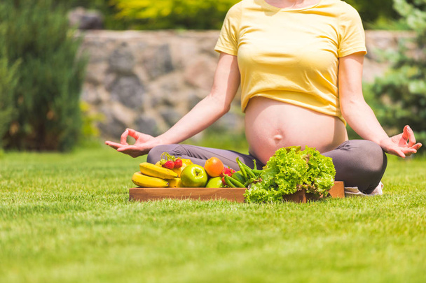 Pregnant woman practicing meditation and relaxation in nature - Foto, immagini
