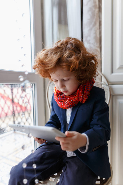 Little redhead boy uses a tablet PC - Fotoğraf, Görsel