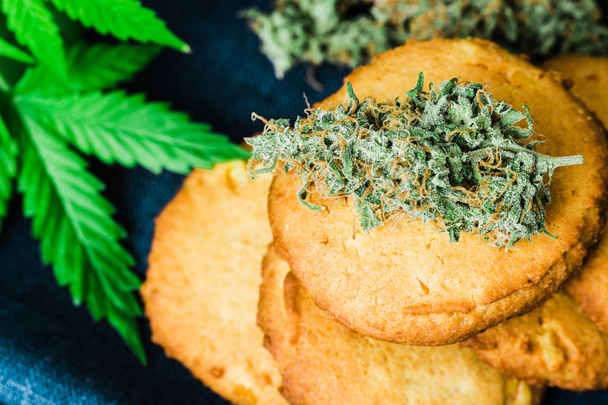 医療大麻とマリファナはテーブルの上の芽とクッキー。大麻の芽大麻ハーブと料理の概念のこと。 ができます黒の背景に、食品で使用するための医療用マリファナの治療 - 写真・画像