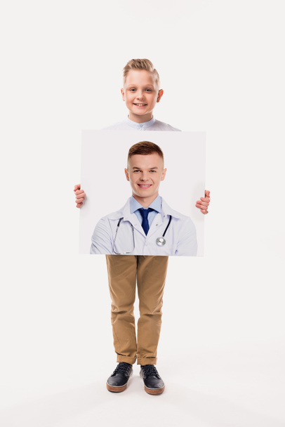 adorable boy pretending to be professional doctor, isolated on white  - Fotó, kép