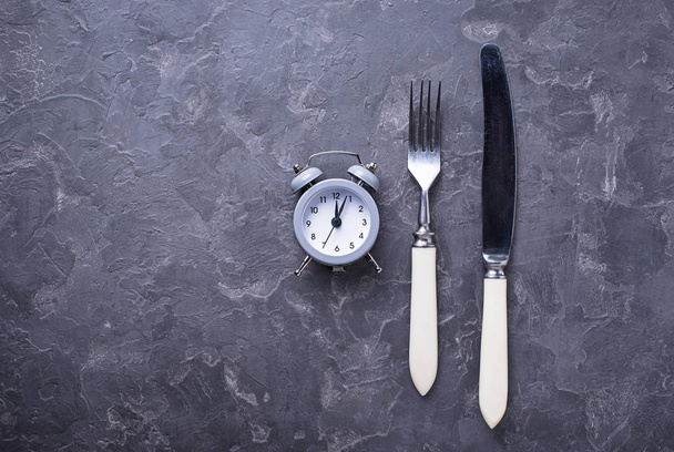 Grey alarm clock with knife and fork - Photo, Image