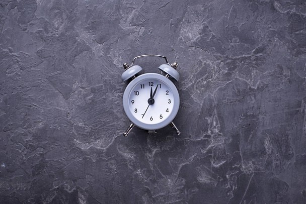 Grey vintage alarm clock on concrete table - Photo, Image
