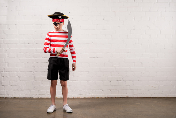 menino fingindo ser um pirata com faca de brinquedo
 - Foto, Imagem