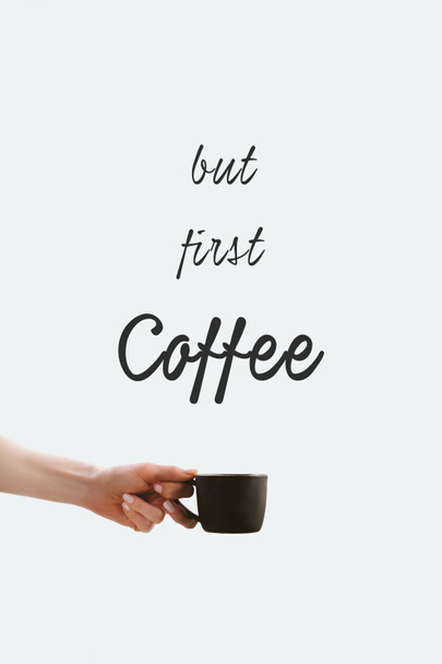 vue recadrée de la main tenant tasse noire de café, isolé sur blanc avec lettrage "Mais premier café"
 - Photo, image