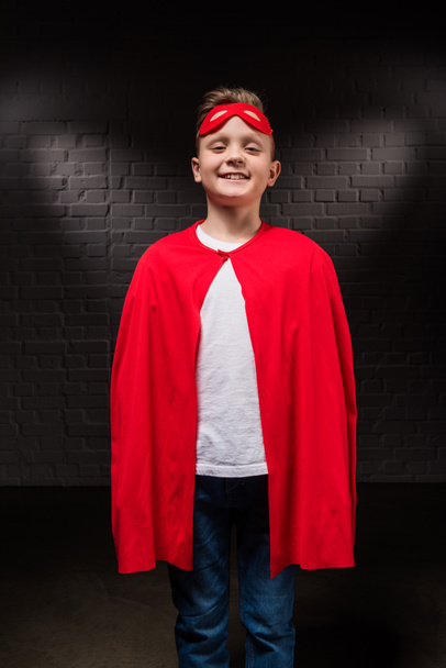 smiling boy in superhero costume and mask - 写真・画像