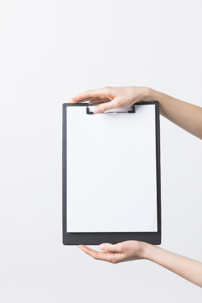 partial view of woman holding blank clipboard in hands isolated on white - Photo, Image