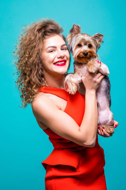 Güzel genç kadın ile sevimli yorkshire terrier köpek, yeşil arka plan üzerinde izole Kırmızı elbiseli - Fotoğraf, Görsel