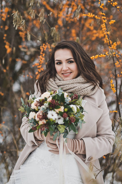 Large portrait of the bride with a bouquet of winter branches of - Fotoğraf, Görsel