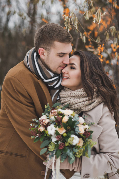 Portrait of a young couple in winter outfits among the branches  - Foto, imagen