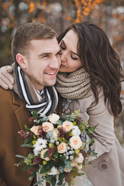 The newlyweds smile happily on a winter walk among the berries o - Foto, Imagem