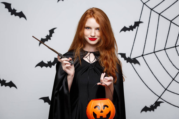 Portrét krásné kavkazské čarodějnice drží oranžová dýně pro oslavu Halloween. - Fotografie, Obrázek
