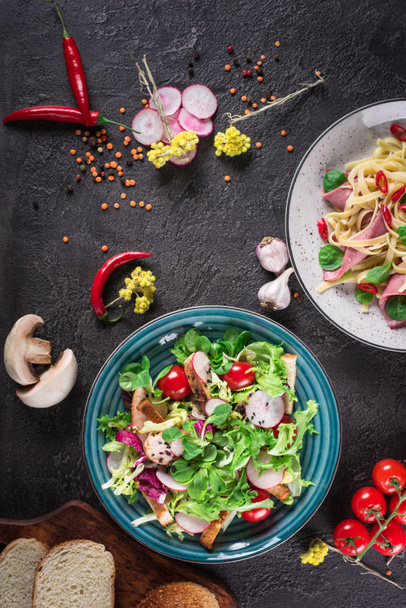 Izgara tavuk göğsü - domates, turp ve karışım marul yaprakları taze sebze salatası. Tavuk salatası. Sağlıklı gıda. Siyah arka plan. Üstten Görünüm - Fotoğraf, Görsel