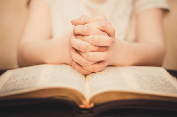 Orando con las manos en la Biblia abierta
 - Foto, imagen