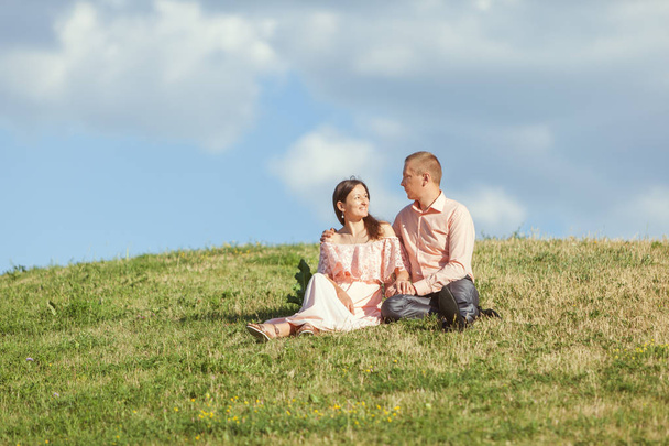 Young loving couple sitting on a hill. - Photo, Image