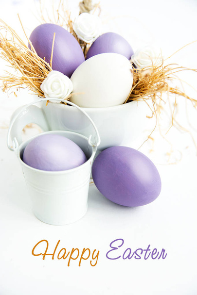 Multi-colored Easter eggs in nest on wooden background, selective focus image. Happy Easter card  - Photo, image