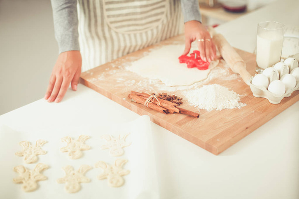 Woman making christmas cookies in the kitchen - Fotó, kép