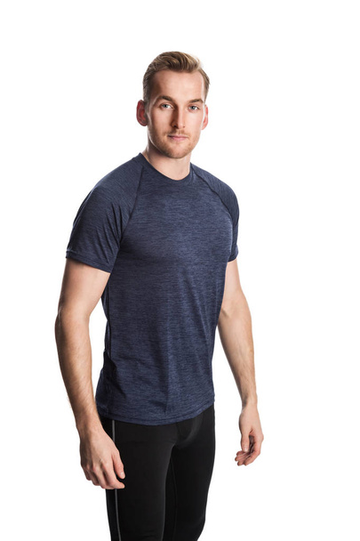 Blonde man wearing workout clothing standing against a white background staring at camera. - 写真・画像