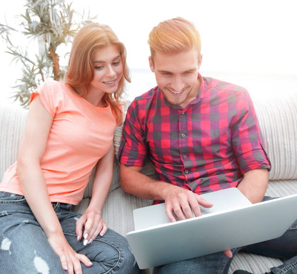 Glückliches modernes Paar surft im Netz und arbeitet zu Hause am Laptop - Foto, Bild
