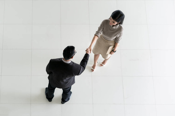 Vue du dessus de l'homme d'affaires asiatique et femme d'affaires serrant la main dans
 - Photo, image